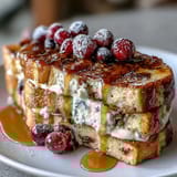 Golden pancake casserole layered with fresh berries and creamy custard, dusted with powdered sugar for a festive Mothers Day brunch centerpiece.