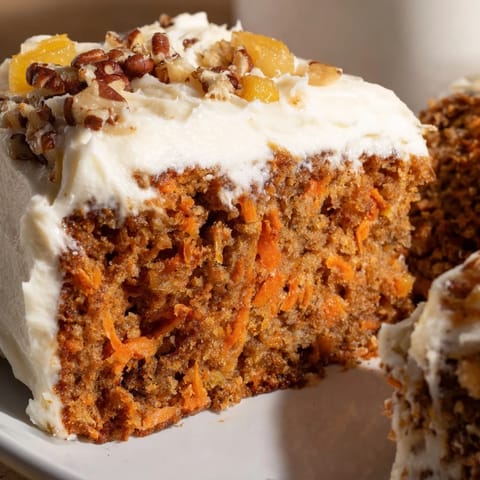 Rich cream cheese tops this homemade carrot cake, perfect for sharing at a gathering.