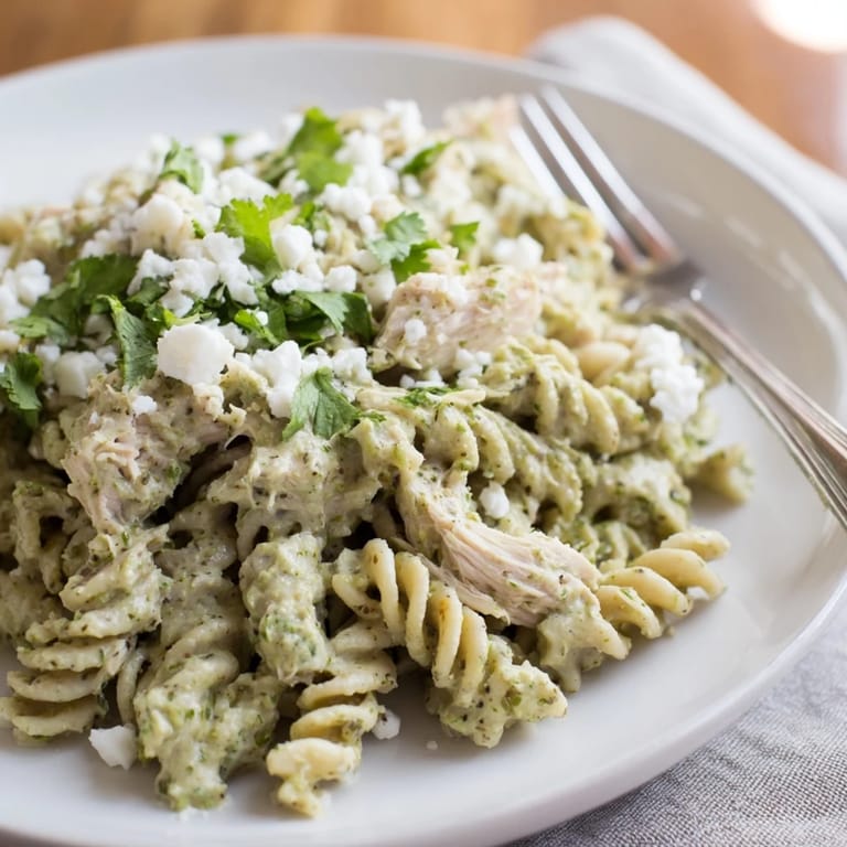 A vibrant bowl of creamy cilantro lime chicken pasta, featuring tender shredded chicken, rotini, and a zesty yogurt sauce with bright herbs.