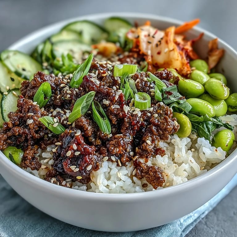 A close-up view of the Korean Ground Beef Bowl showcasing the glossy gochujang sauce and colorful fresh toppings.