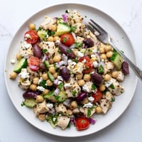 Freshly prepared Mediterranean Chickpea Chicken Salad with juicy diced chicken, creamy feta cheese, crisp cucumber, and briny Kalamata olives in a zesty lemon dressing.